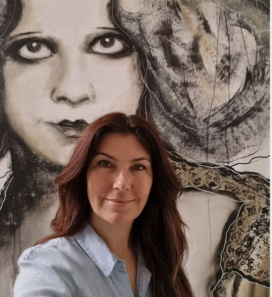 Elise Judd of Gotham Studios Collective standing in front of a large black and white artistic portrait.